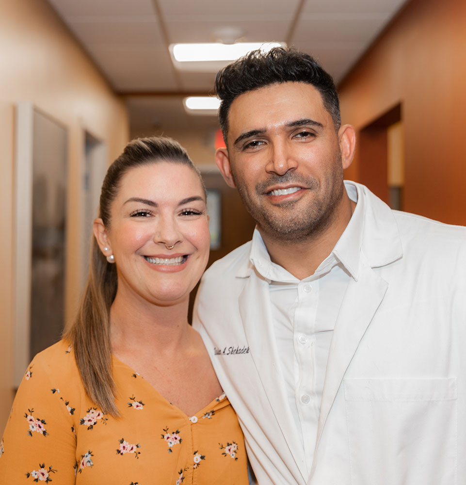 Dr. Bashar A. Shehadeh smiling alongside a patient at the dental office.